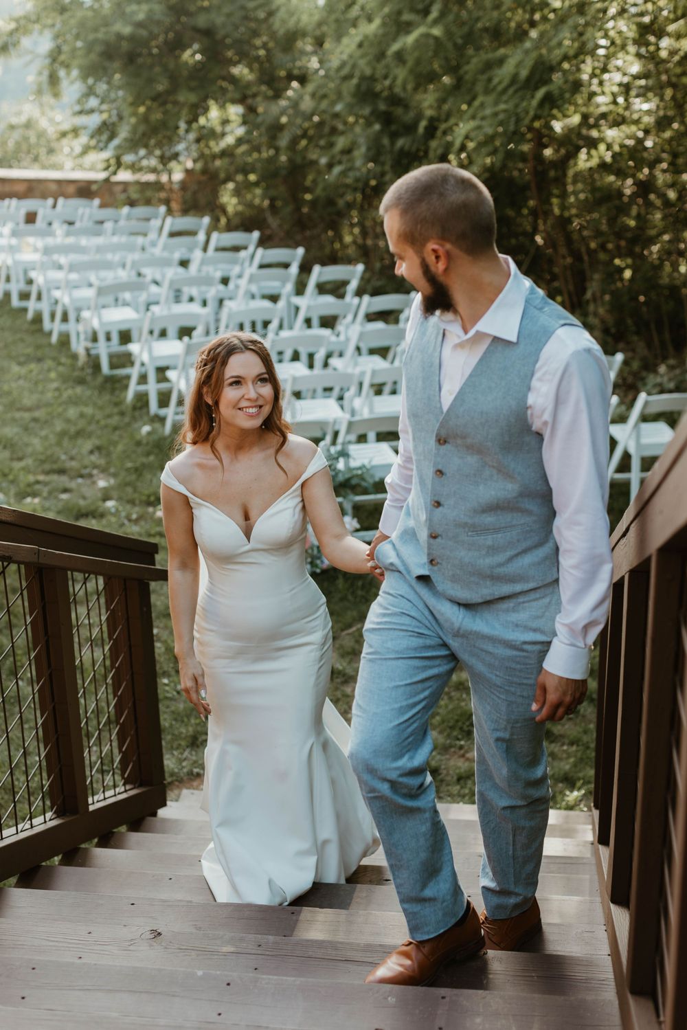 Couple shares romantic moments on wooden bridge during wedding celebration.