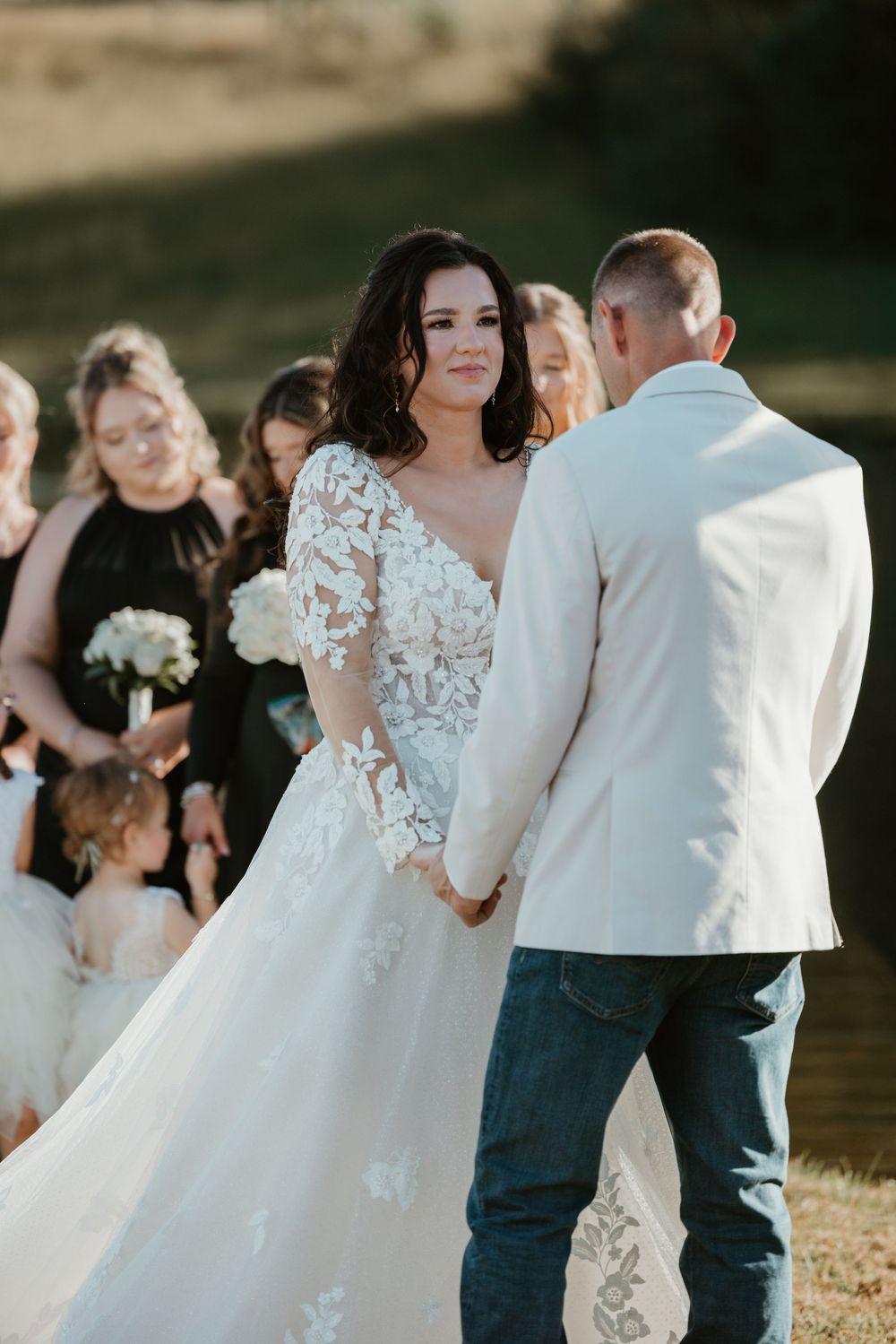 Wedding ceremony with couple at altar surrounded by bridal party.