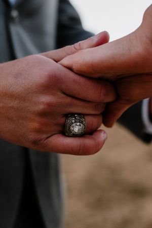 Close-up of hands with an ornate ring during an intimate wedding moment.