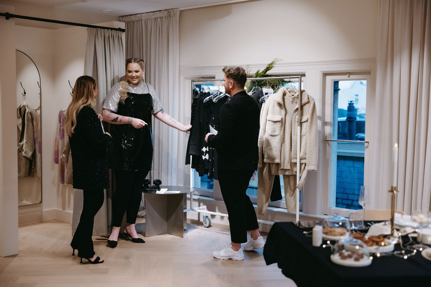 People interact in a bright retail space with clothing racks and displays.