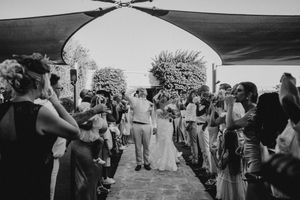 Black and white photos show a wedding celebration with guests dancing and mingling under an outdoor tent.