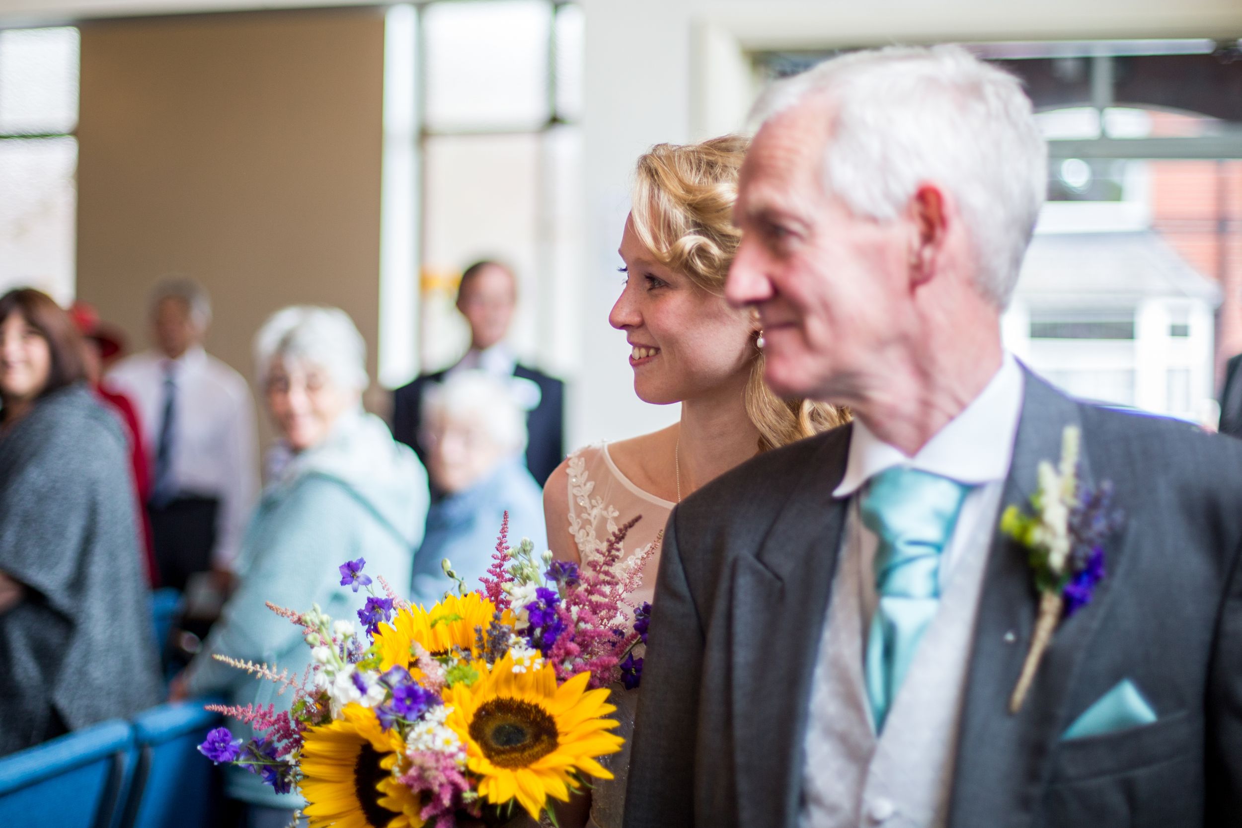 Wedding guests enjoy a bright moment with vibrant sunflowers and colorful bouquets.