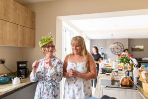 Wedding guests enjoy drinks and conversation in a modern kitchen setting.