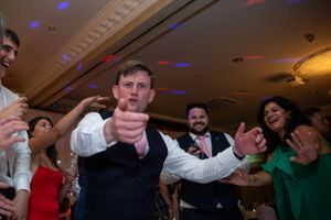Energetic dance party scene with colorful lights and celebration at an indoor venue.