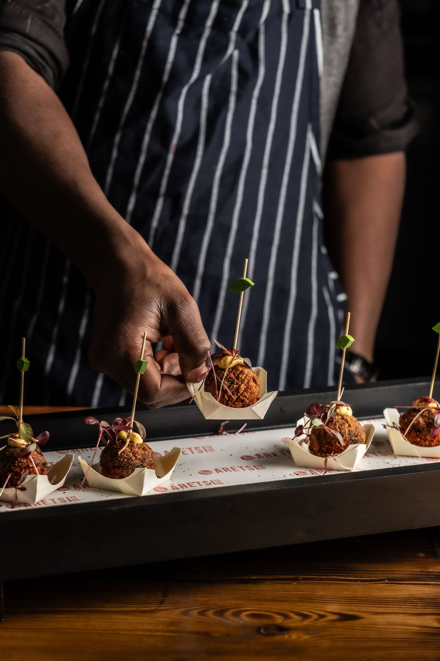 Lifestyle/action shot of vegetable pakora samosa being reach for from canapé platter, Aretsi based in Birmingham.