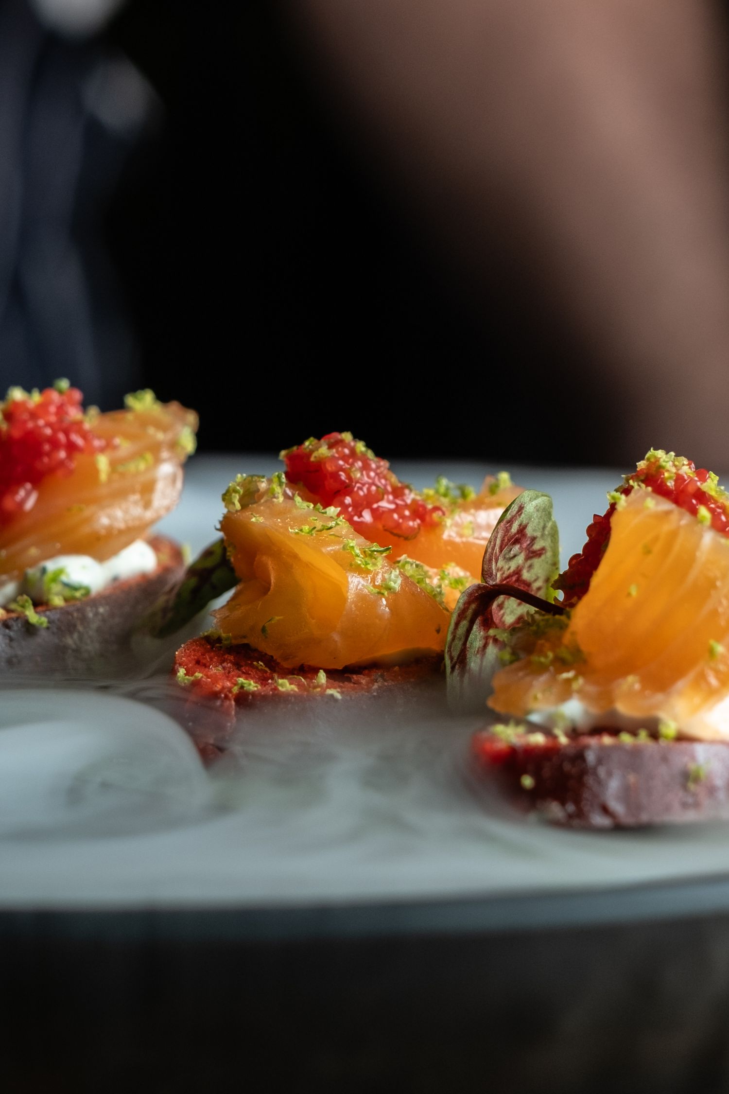 Close up of smoked salmon luxury canapé surrounded by dry ice for outside catering Aretsi based in Birmingham.