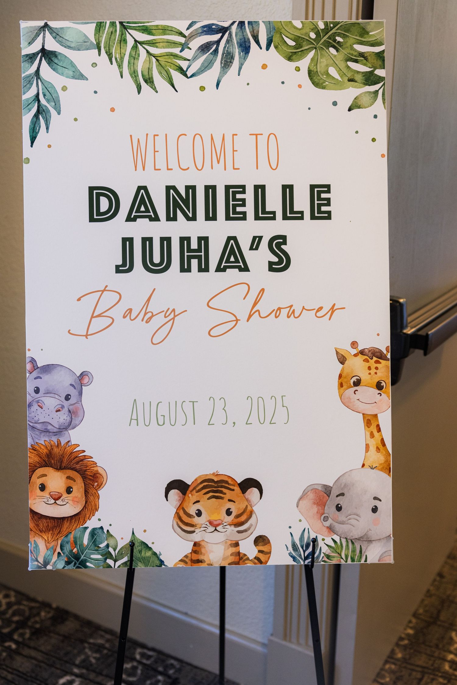 Safari-themed baby shower welcome sign for Danielle Juha on August 23, 2025, featuring cute jungle animals and tropical leaves.