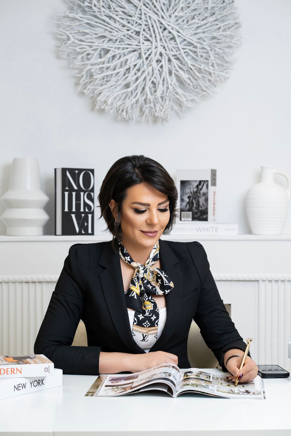 Professional working at white desk with modern decor and wall art.