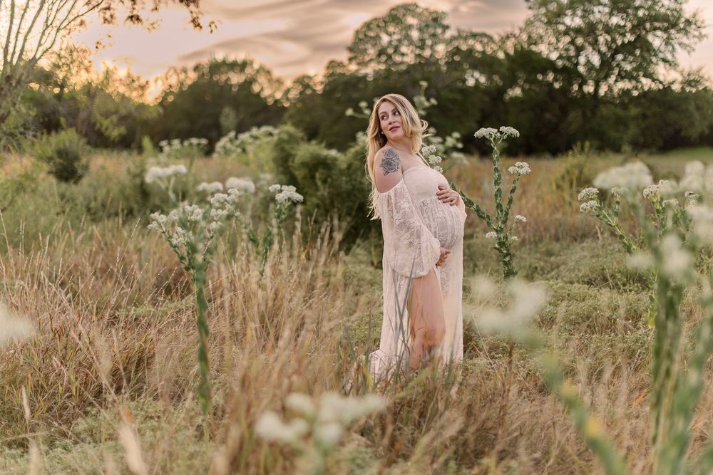 A dreamy golden hour photoshoot in a wildflower meadow with soft natural lighting and tall grass.