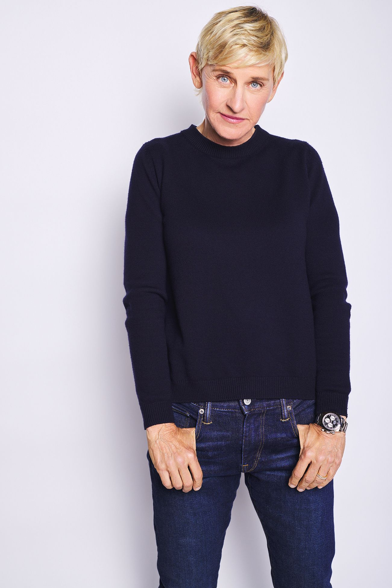 Ellen DeGeneres publicity photo wearing a navy sweater and jeans against a white background
