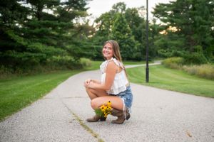 Series of outdoor portraits taken on a gravel path surrounded by pine trees.
