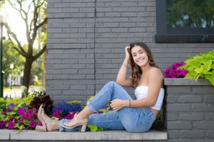 A series of casual outdoor portraits taken against a gray brick wall with colorful flowers in the background.