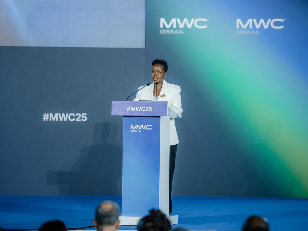 A person speaking at a technology conference podium with MWC branding and blue lighting in the background.