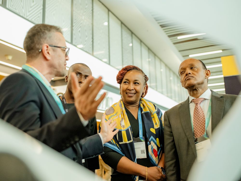 Business professionals in suits and casual attire engage in animated conversation during a networking event.