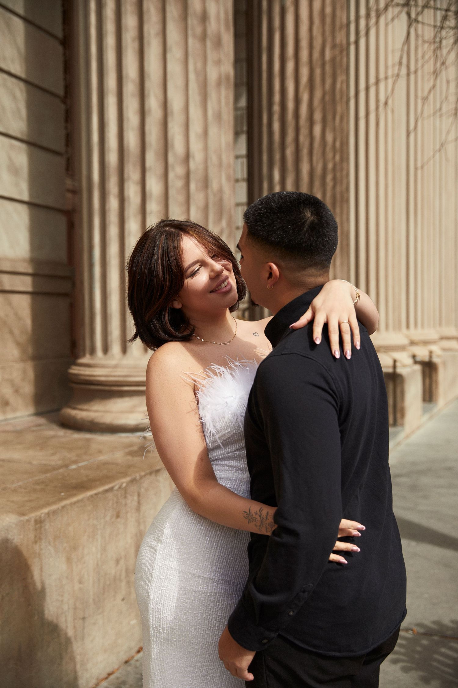 Intimate wedding portrait captured against classic stone columns.
