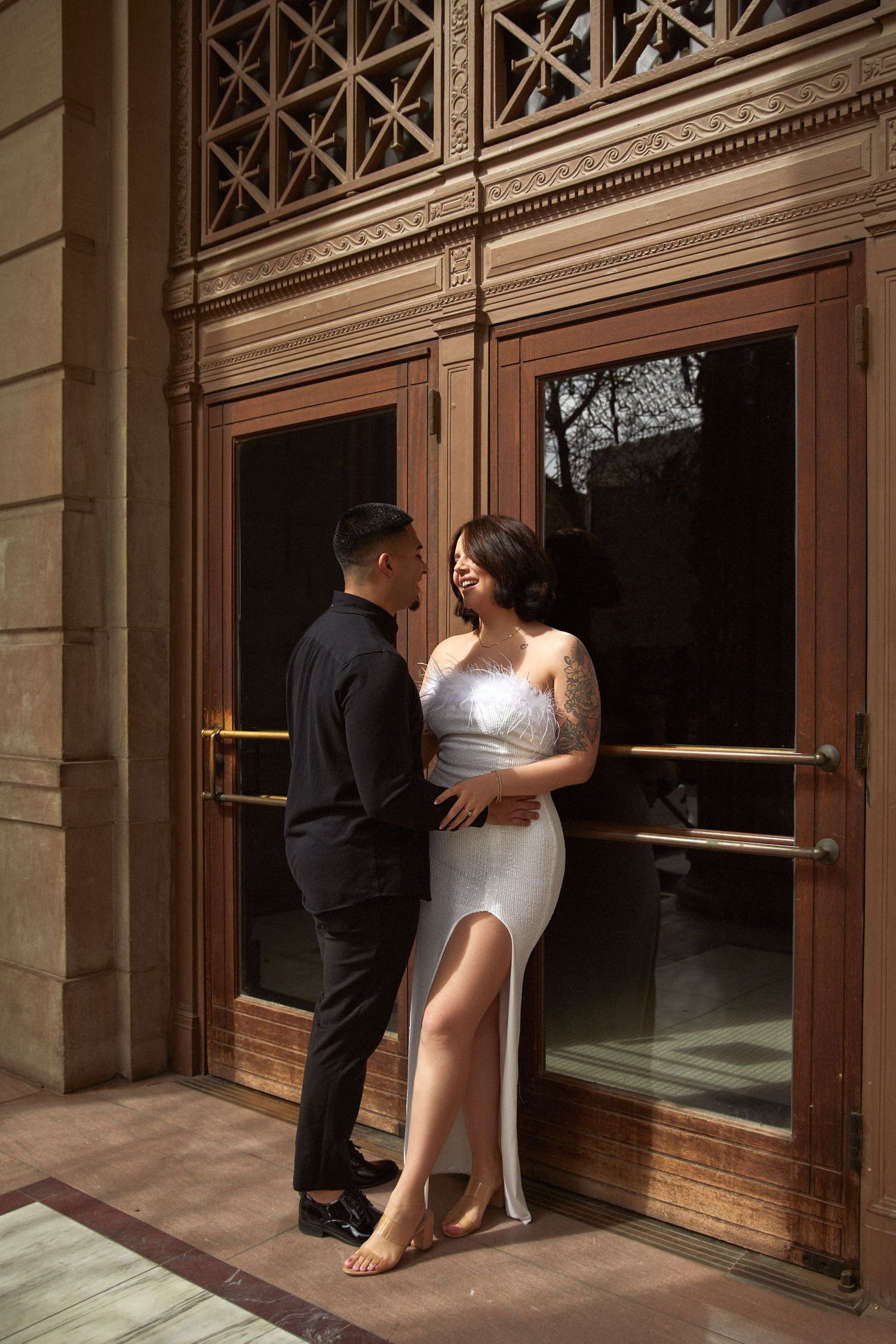 Romantic wedding photo series showing couple by ornate wooden doors and columns.