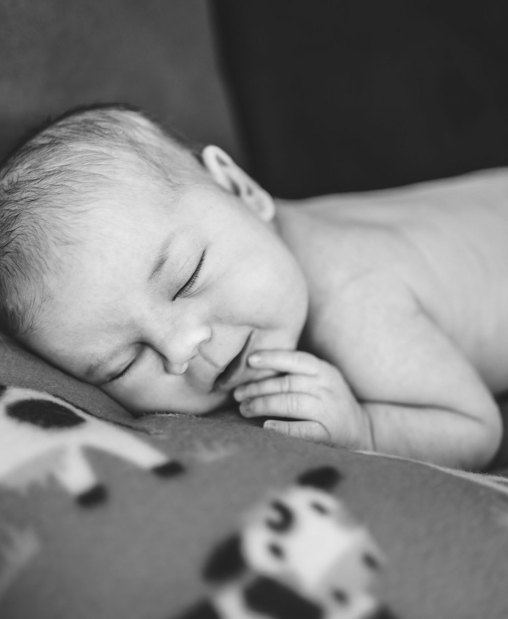 Black and white close-up images showing a sleeping baby in peaceful repose.