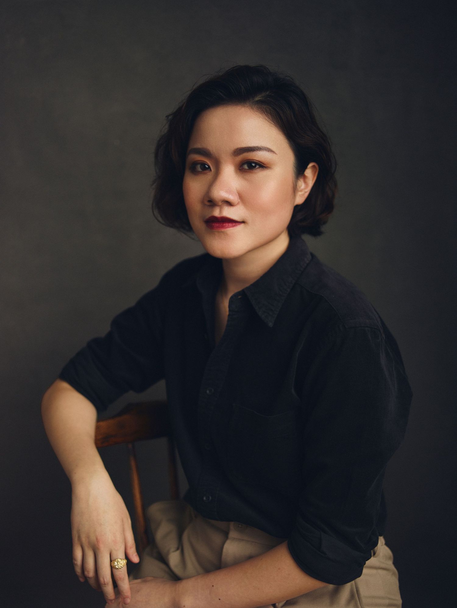Studio portrait series with subject in black clothing against dark dramatic background.
