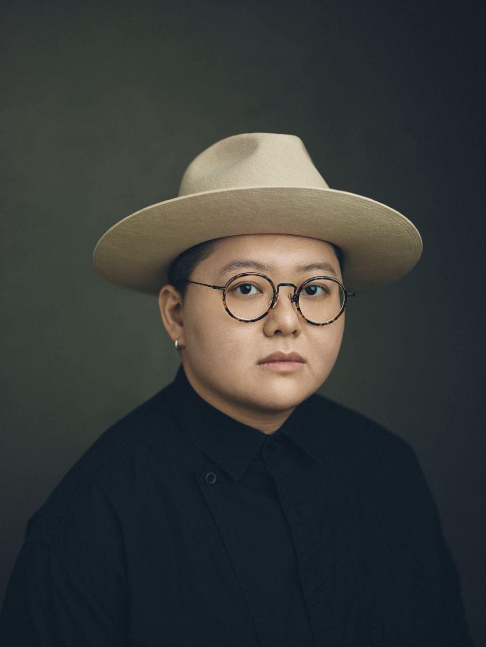 Dramatic portrait series featuring person in black outfit and wide-brimmed hat.