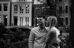 Black and white portrait of a happy couple laughing against historic buildings. new york neighborhood engagement photos