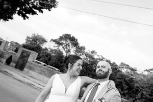A happy couple shares a joyful moment together in black and white photography outdoors.