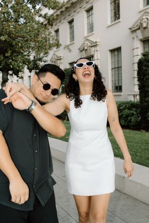 Editorial, cool, Los Angeles couple laughing in engagement outfits.