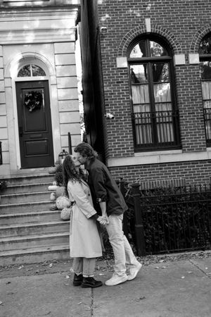 A sequence of black and white photos showing two people interacting on the steps of a brick building.