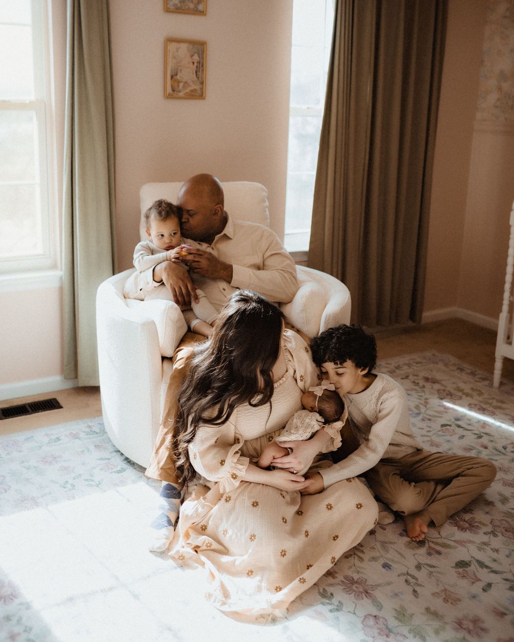 A cozy scene of people relaxing together on a plush white couch in a sunlit living room.