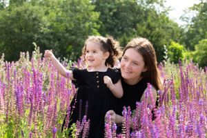 Family portrait session among vibrant purple wildflowers in full bloom.