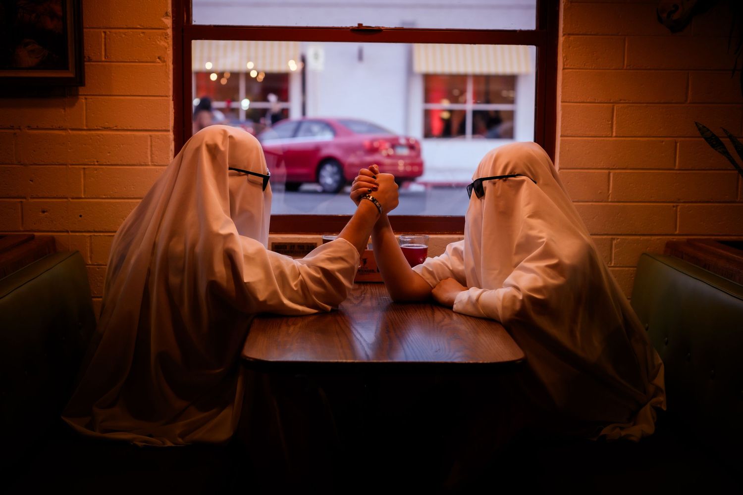 Two people in silhouette sit facing each other near a window with warm lighting creating an intimate atmosphere.