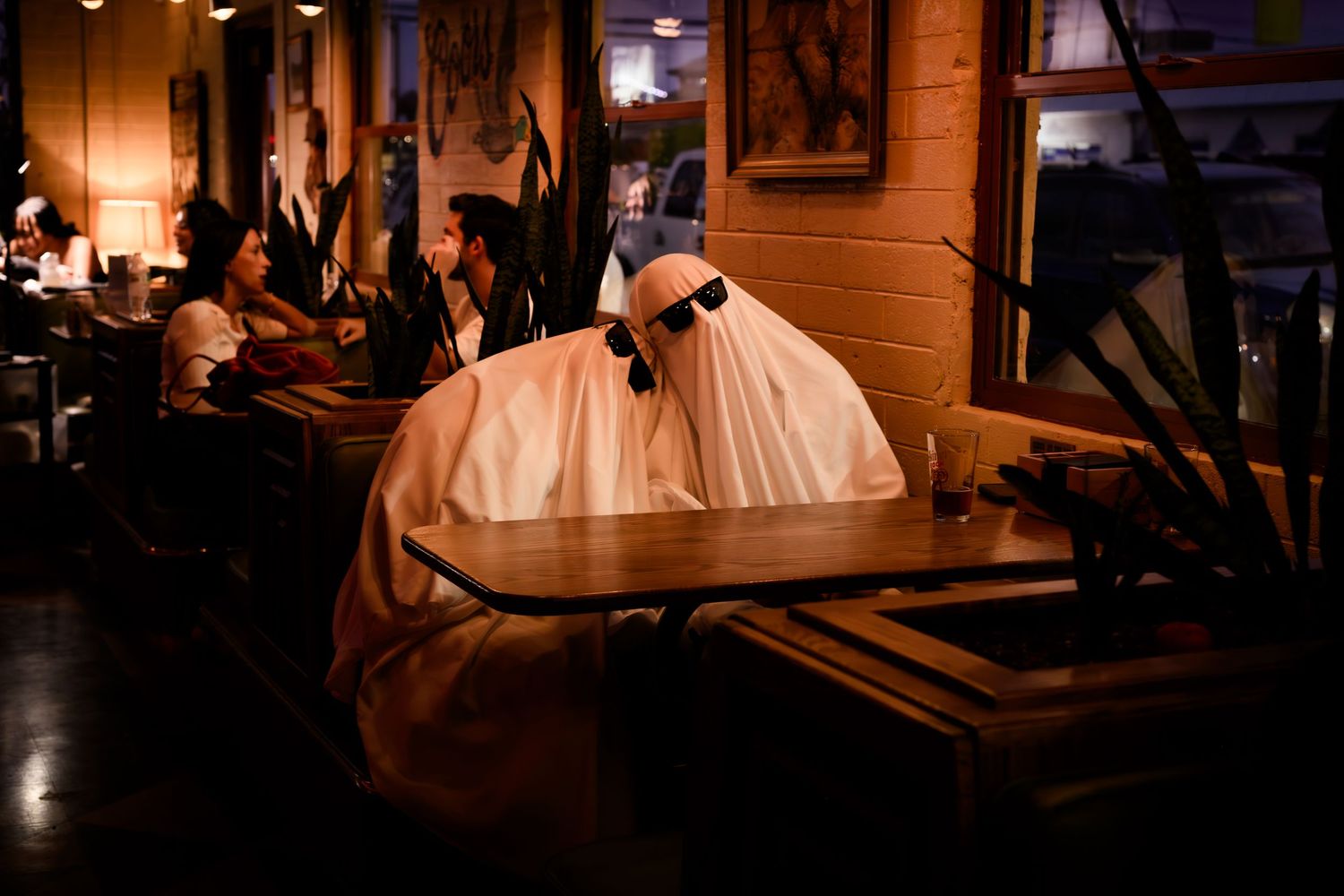 A ghost-like figure plays a grand piano in a dimly lit bar setting.