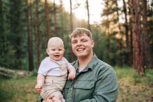 A warm outdoor portrait session in a pine forest during golden hour.