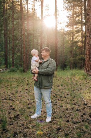 A tender moment captured in a sunlit forest clearing.