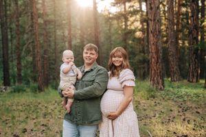 A family portrait in a pine forest during golden hour.
