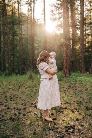 A tender moment captured in a pine forest during golden hour.