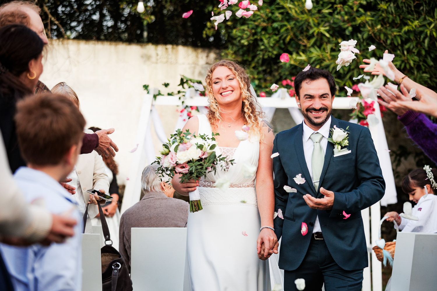 Bride and groom joyfully walking back down the aisle as newlyweds.