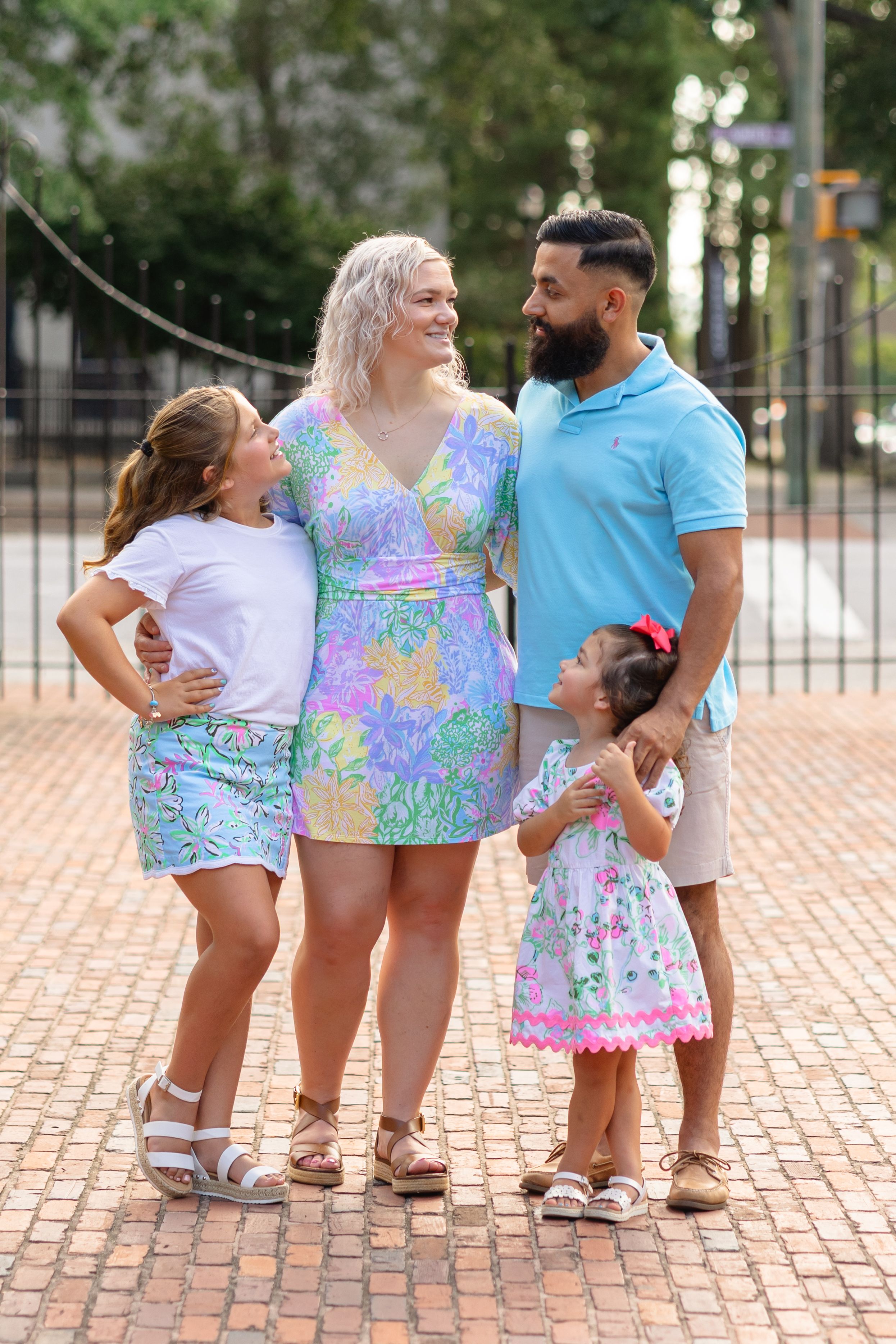 A group wearing matching tie-dye outfits poses playfully on brick pavement in a progressive sequence of photos.