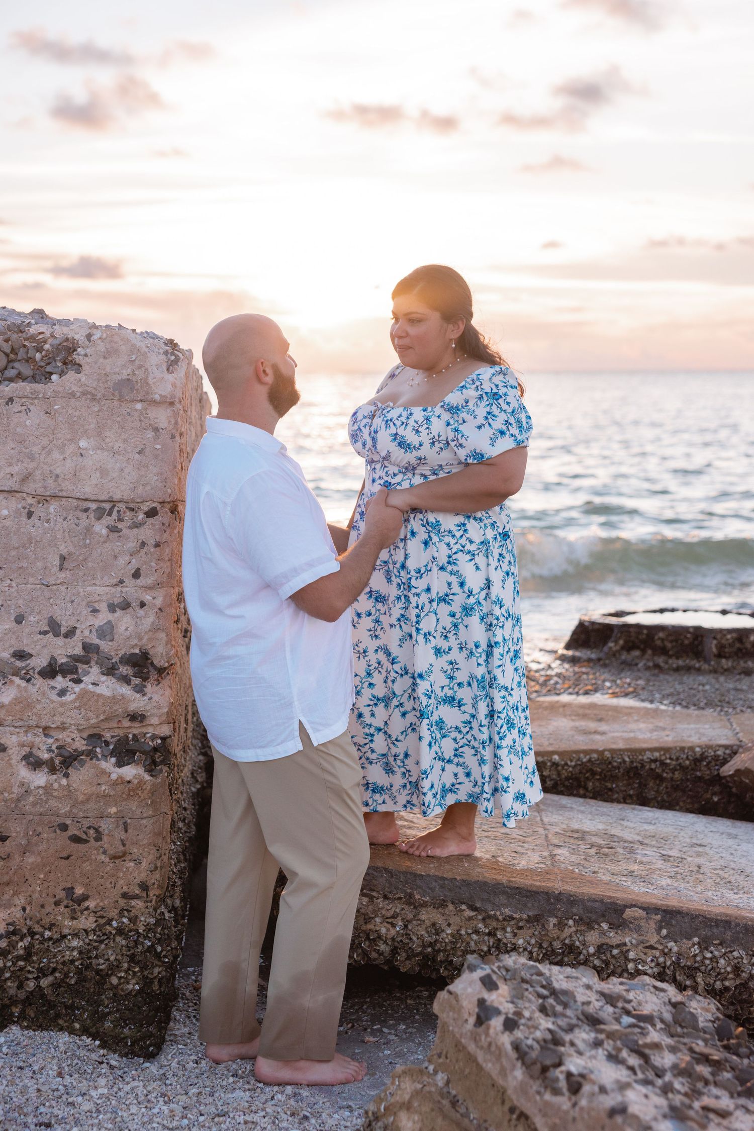 A family stands together along the shoreline during a beach portrait session.