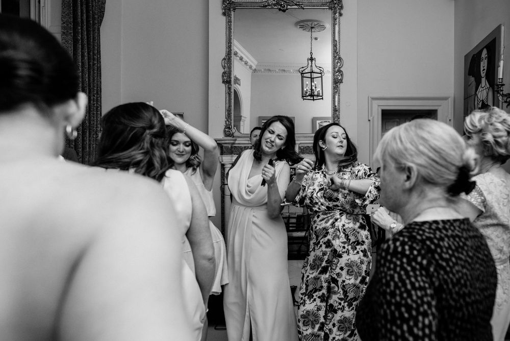 A group of friends laughing and celebrating together at an indoor party in black and white photography.