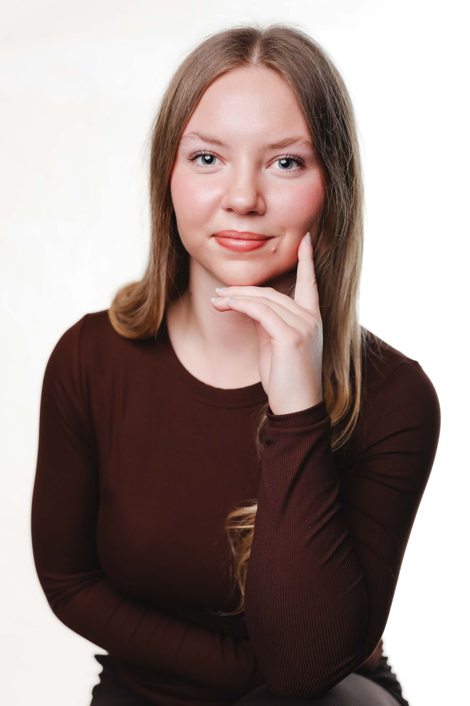 A series of four similar portraits showing someone in a brown sweater making playful expressions against a white background.