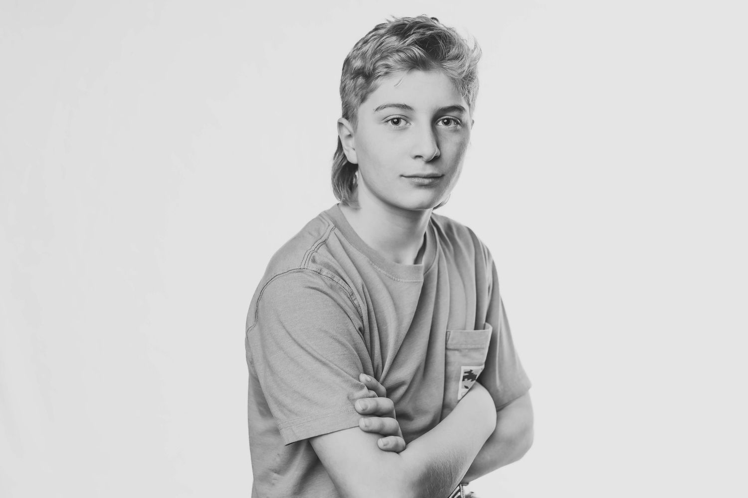 Four black and white photos show someone in a casual t-shirt posing against a plain background.