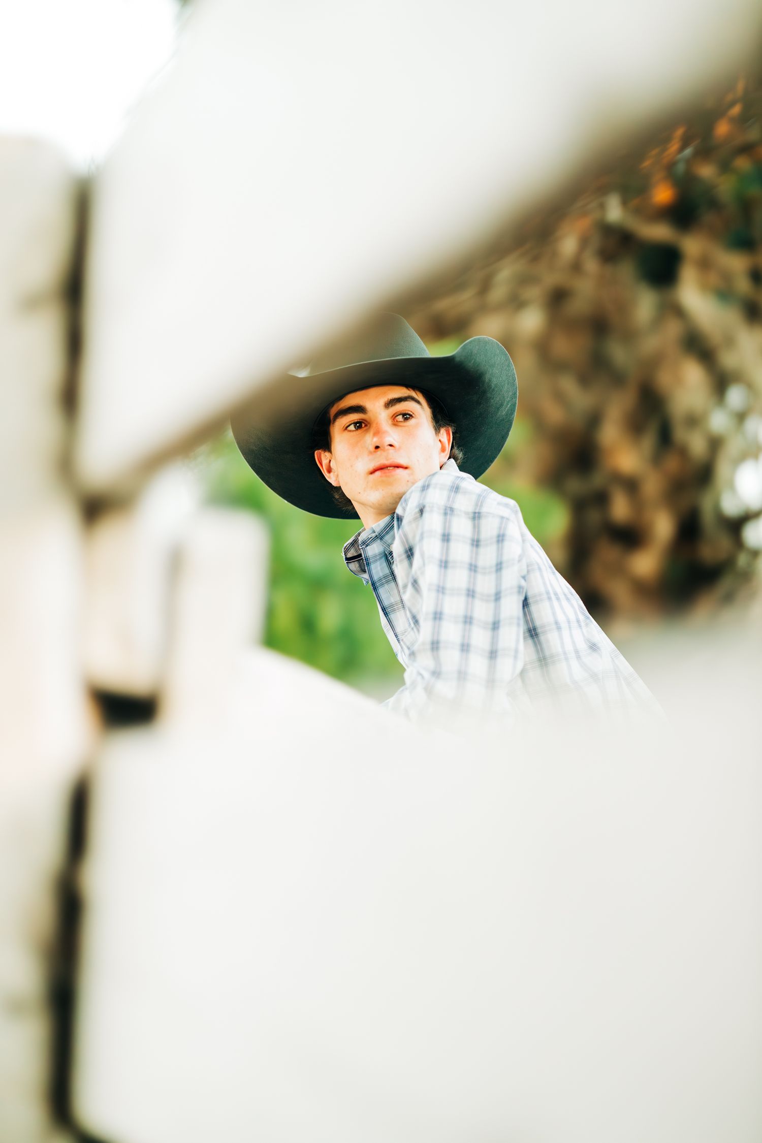 A high school senior standing on a wood fence looking behind him, Casmalia, CA
