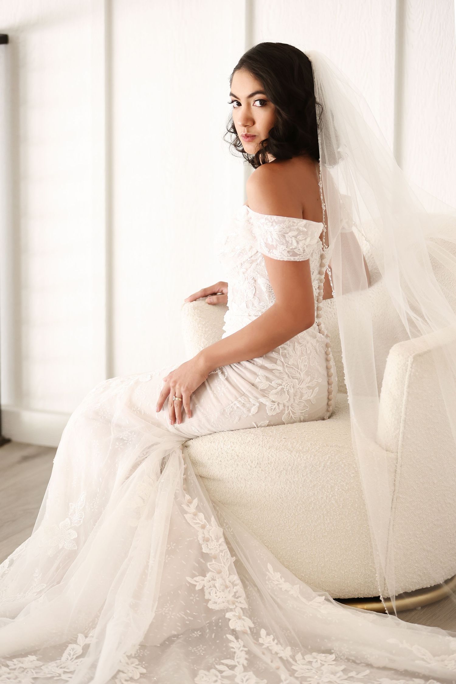 Elegant bridal portraits featuring a white lace gown against a bright white backdrop.