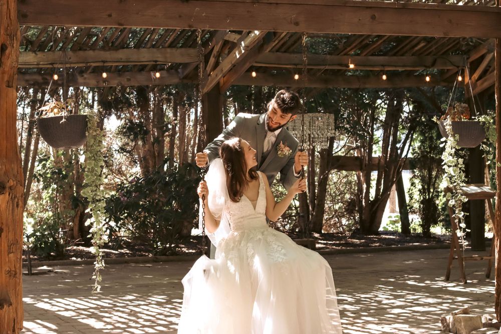 Bride and groom share first dance under string lights in rustic outdoor venue.