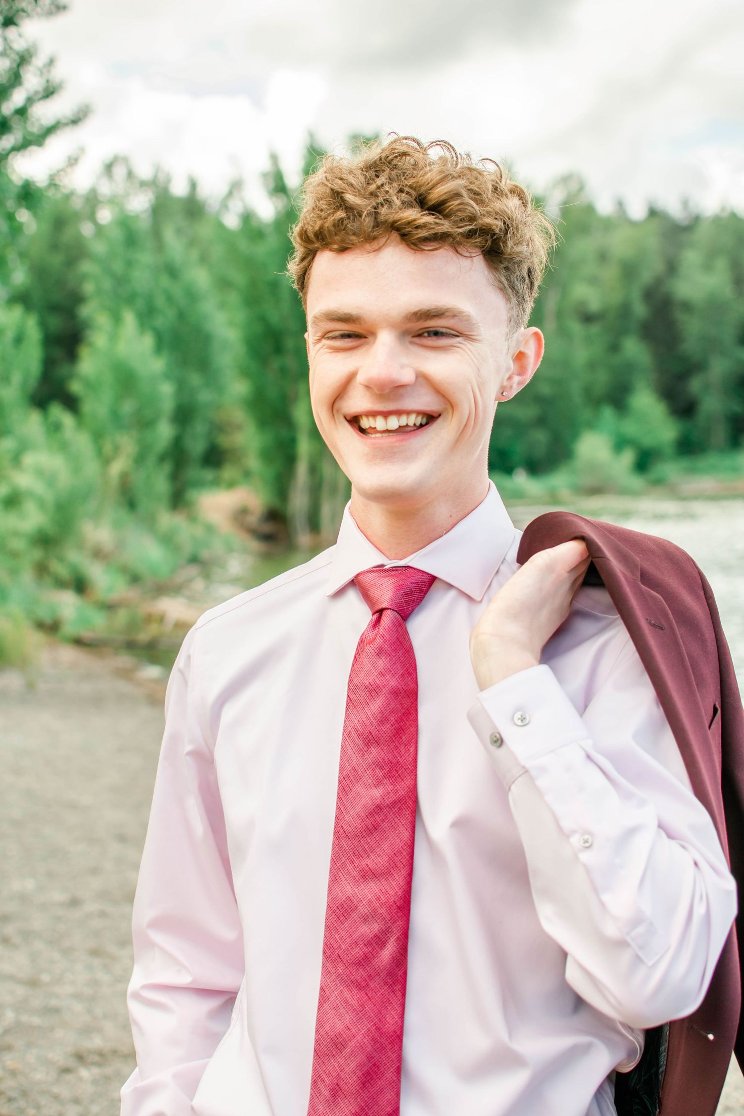 Outdoor portrait series in a grassy field with mountains visible in the background.