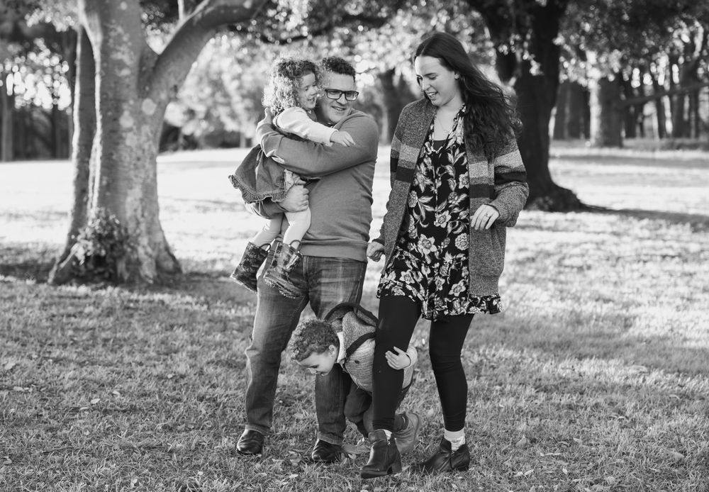 A family enjoying quality time together outdoors in a park setting, captured in black and white.