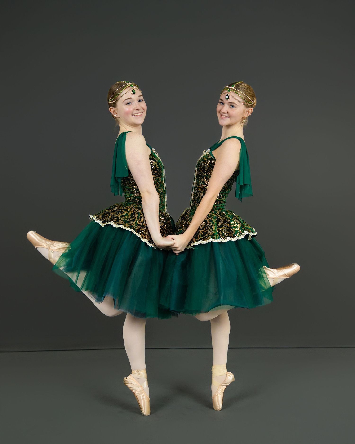 A dancer poses in a sparkly purple performance dress with layered tulle skirt.