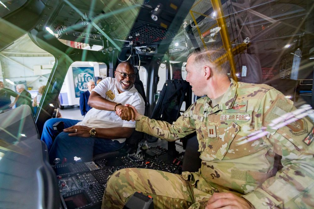 Military service member interacts during an informal gathering inside aircraft or vehicle.