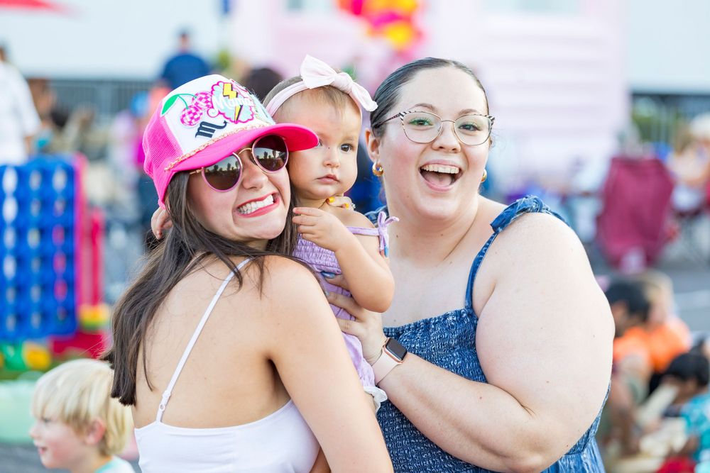 Festival attendees sharing joyful moment at outdoor community event.