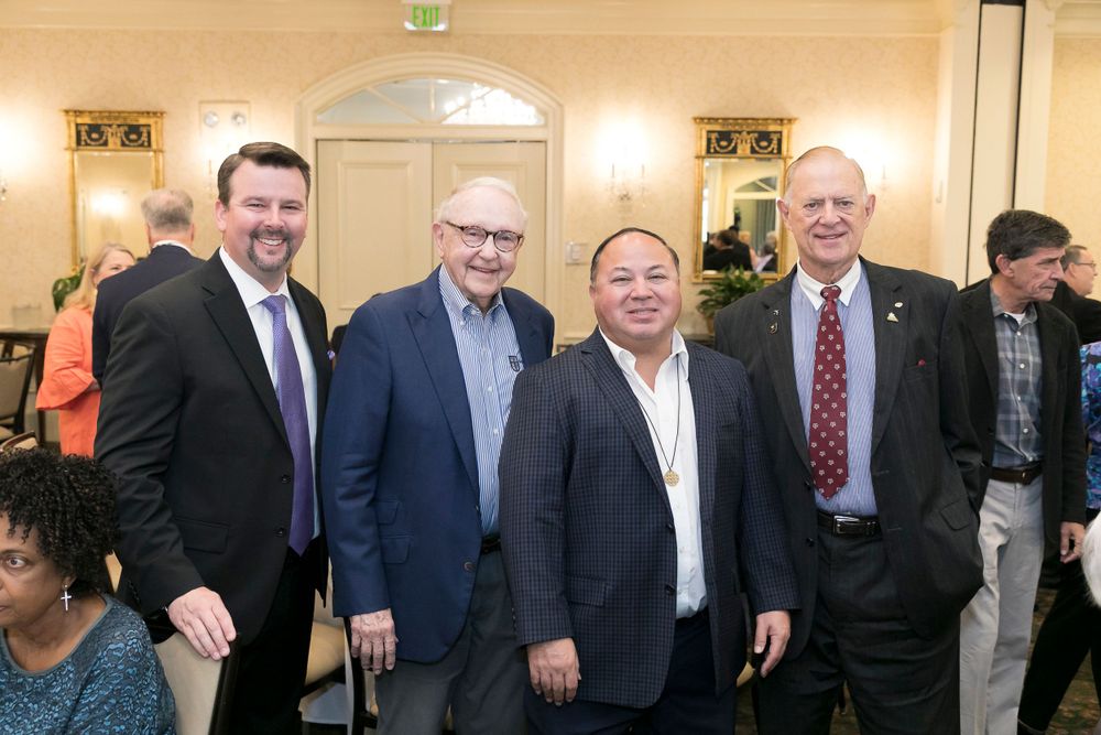 Small group of business and government officials pose together at formal event.